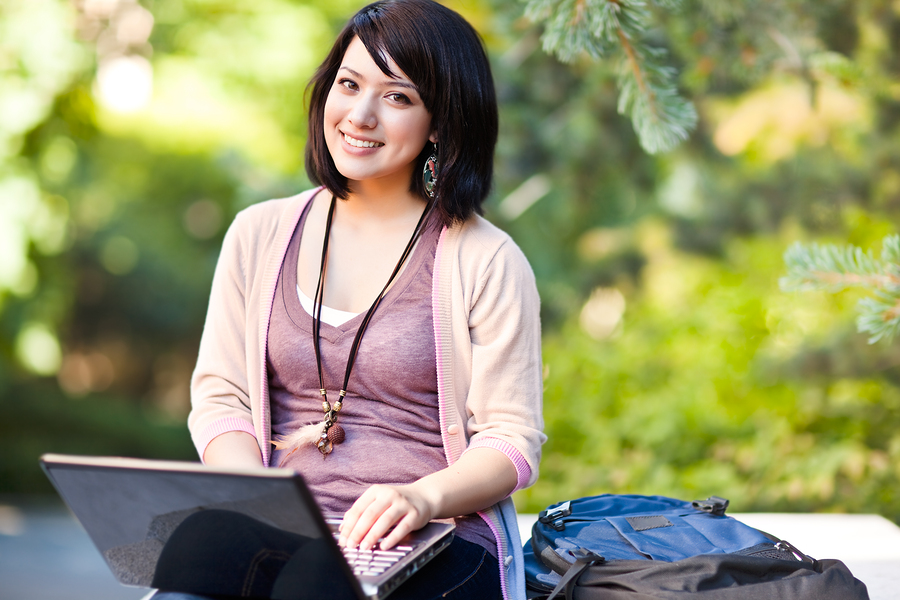 Mixed race college student working on laptop at campus